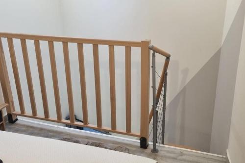 un escalier en bois avec une rampe à côté d'un mur dans l'établissement Air Cosy 3 Valenciennes gare prostitution refusée, à Valenciennes
