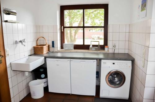 a kitchen with a sink and a washing machine at Ferienhaus Ostebogen in Hechthausen