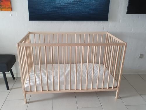 a crib with a white mattress in a room at Airbnb-lejligheder, Villerslev in Villerslev