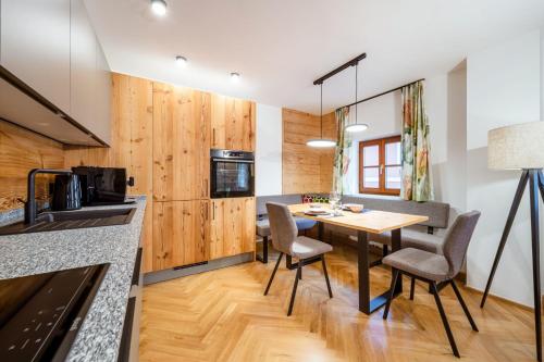 a kitchen and dining room with a table and chairs at Thorbäck Gut - Apartments im Schlosserhaus in Öblarn