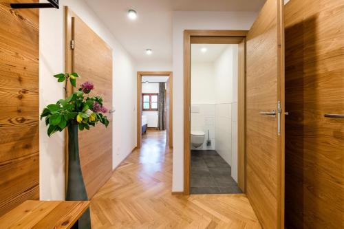 a hallway with a door and a vase with flowers at Thorbäck Gut - Apartments im Schlosserhaus in Öblarn