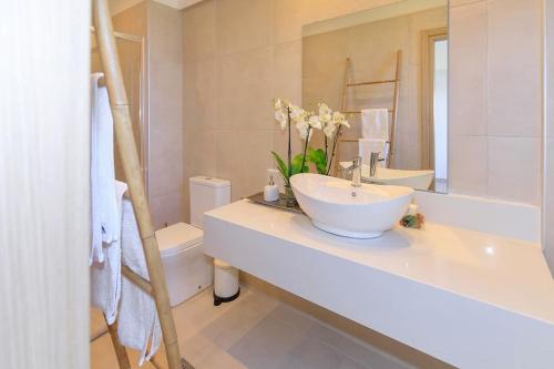 uma casa de banho com um lavatório, um WC e um espelho. em Dilean luxury villa em Vourvourou
