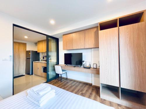 a bedroom with a bed and a kitchen with cabinets at Nara lahabana in Hua Hin