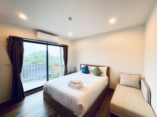 a bedroom with a bed and a large window at Nara lahabana in Hua Hin