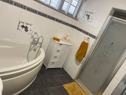 a white bathroom with a shower and a toilet at Spacious 1 bed bungalow located on a Gower Sheep Farm in Swansea