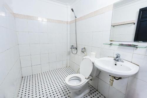 a white bathroom with a toilet and a sink at Casablanca Hotel in Hue