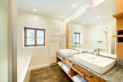 a bathroom with two sinks and a mirror at Thorbäck Gut - Apartments im Schlosserhaus in Öblarn