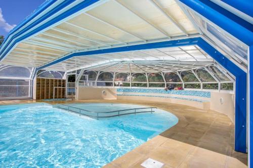 una grande piscina con un grande edificio in vetro di Camping Ostréa **** a Dolus-d'Oléron