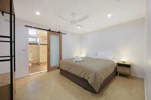 um quarto com uma cama e uma porta para uma casa de banho em Logans Beach Apartments - BeachHouse em Warrnambool
