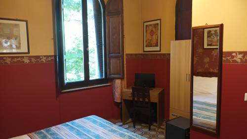 a bedroom with a bed and a desk and a window at Hotel Europa in Perugia