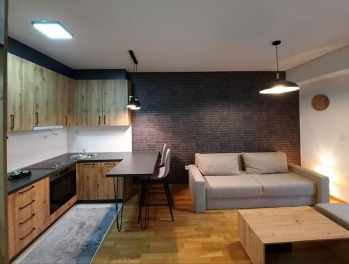 uma cozinha e sala de estar com um sofá e uma mesa em Cozy one-bedroom apartment in Skopje em Skopje