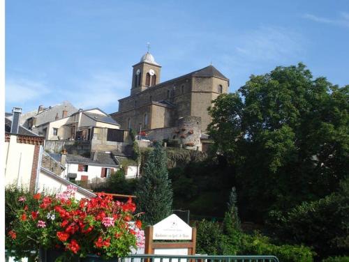 a building on top of a hill with trees and flowers at Gite Volupté in Montcy-Notre-Dame