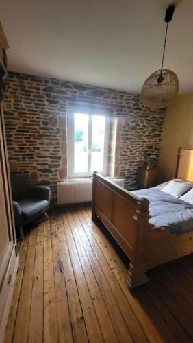 a bedroom with a bed and a brick wall at Gite Volupté in Montcy-Notre-Dame