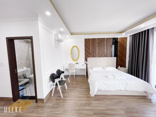 1 dormitorio blanco con 1 cama grande y espejo en Minh Homestay, en Thôn Lại Thê