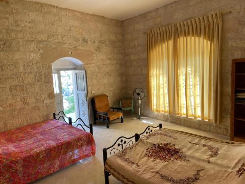 Un pat sau paturi într-o cameră la Dar Ateeq's Arches/ Bethlehem Apartment