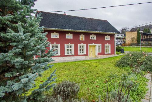 une maison rouge avec un arbre devant elle dans l'établissement apartmán 1kk Zlámanka, à Kroměříž