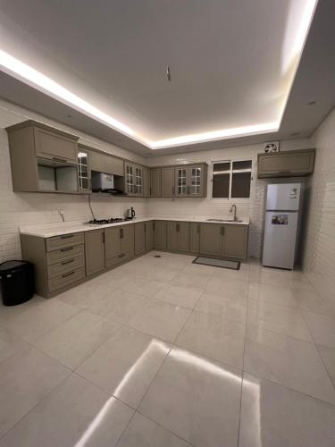 a large kitchen with white appliances and a large tile floor at شقة بغرفتي نوم وصالة جلوس in Al Madinah