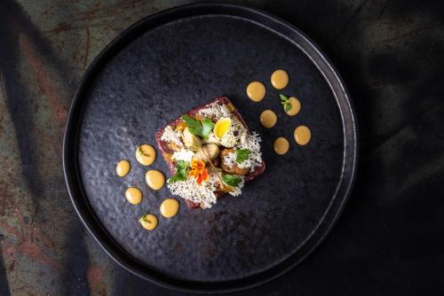 a black plate with a piece of food on it at Hotel Crocus in Zakopane