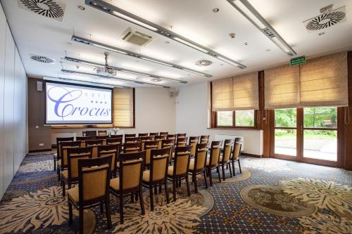 a conference room with a stage and a bunch of chairs at Hotel Crocus in Zakopane