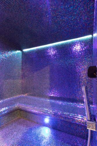 a purple bathroom with a tub with purple lights at Hotel Crocus in Zakopane