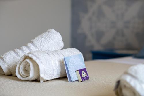 un rollo de toallas blancas en una cama en Villa Silencia en Pag