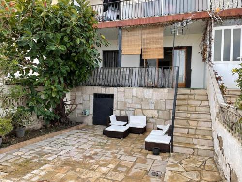 Apartamento en el centro de Miami Platja 155B - INMO22 في هوسبيتاليت دي لانفنت: فناء فيه كنب وكراسي امام مبنى