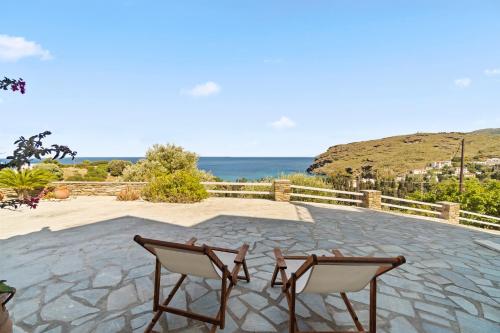 a patio with two chairs and the ocean in the background at Seaside & Modern Flats near Chora in Steniaí