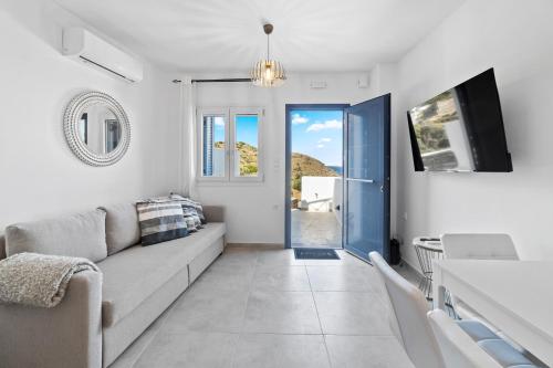 a living room with a couch and a tv at Seaside & Modern Flats near Chora in Steniaí