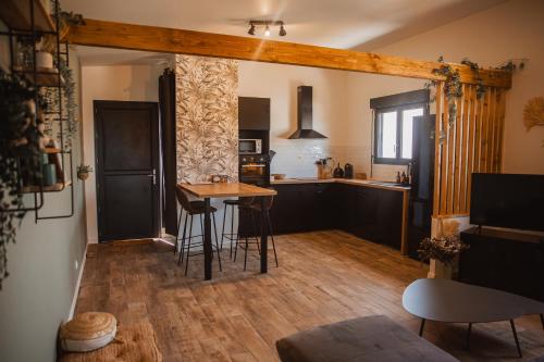 een keuken met een tafel en stoelen in een kamer bij « La Casa Normande » entre Ville & Plages in Esquay-sur-Seulles