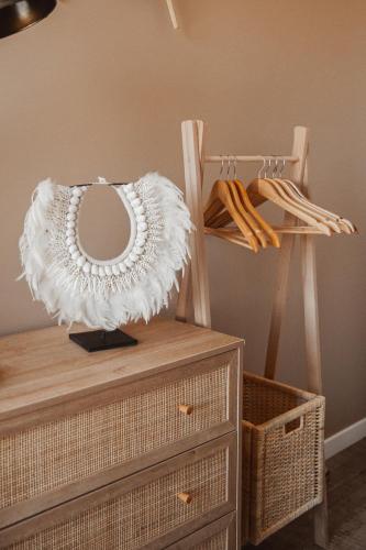 un miroir au-dessus d'une commode à côté d'une chaise dans l'établissement « La Casa Normande » entre Ville & Plages, à Esquay-sur-Seulles