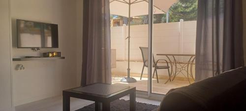 a living room with a table and an umbrella at Antheor cap Roux in Saint-Raphaël