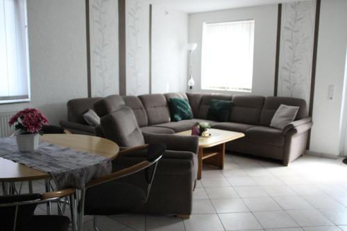 ein Wohnzimmer mit einem Sofa und einem Tisch in der Unterkunft Ferienwohnung Drieling, 85091 in Ostrhauderfehn