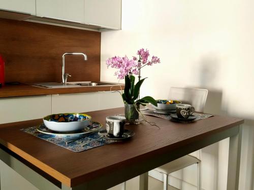 a kitchen table with two bowls and a vase of flowers at PALAZZO ZUPPARDO LUXURY in Agrigento