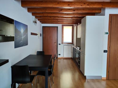 une cuisine et une salle à manger avec une table et des chaises noires dans l'établissement Fabula Home Rental - La Rocca, à Castro