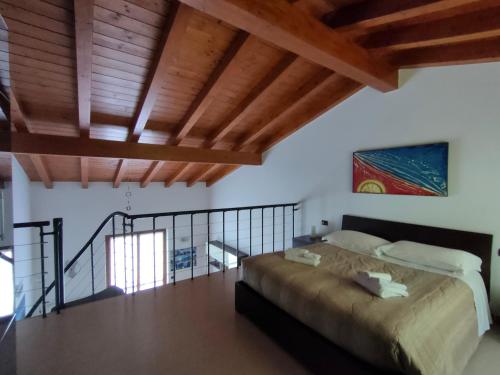- une chambre avec un lit dans une pièce dotée de plafonds en bois dans l'établissement Fabula Home Rental - La Rocca, à Castro