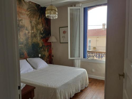 een slaapkamer met een bed en een groot raam bij Casa azul & blanca in Banyuls-sur-Mer