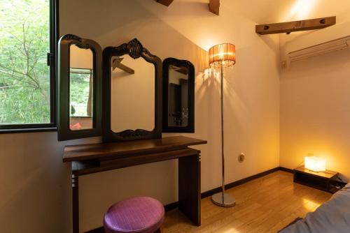 a room with a mirror and a bed and a lamp at HAYATO HAKONE GUEST HOUSE in Hakone