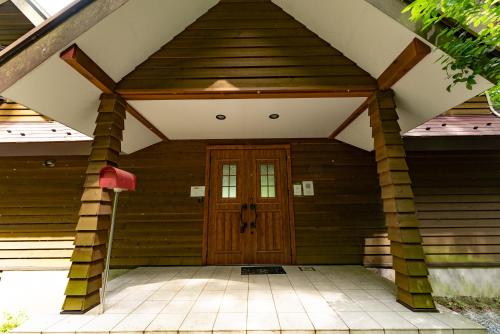 a wooden front door of a house with a porch at HAYATO HAKONE GUEST HOUSE in Hakone