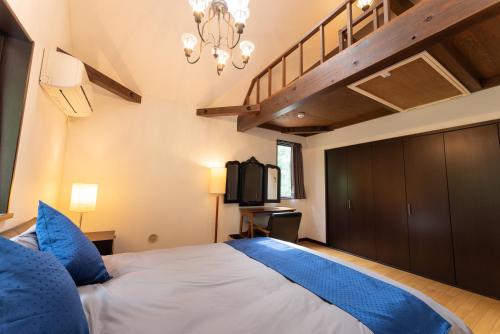a bedroom with a large bed with blue pillows at HAYATO HAKONE GUEST HOUSE in Hakone