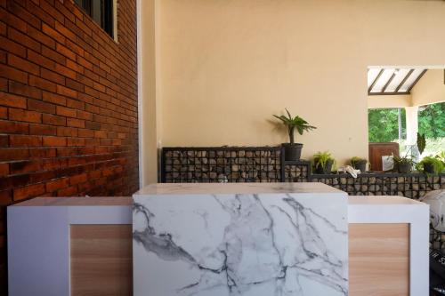 a marble counter in a room with a brick wall at RedDoorz at Tasneem Puspowarno Semarang in Kalibanteng-lor
