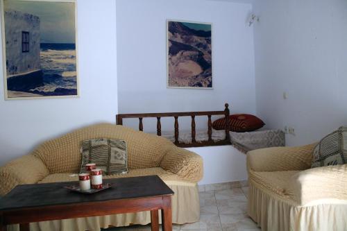 a living room with two couches and a table at Volcano View Nisyros in Mandrákion