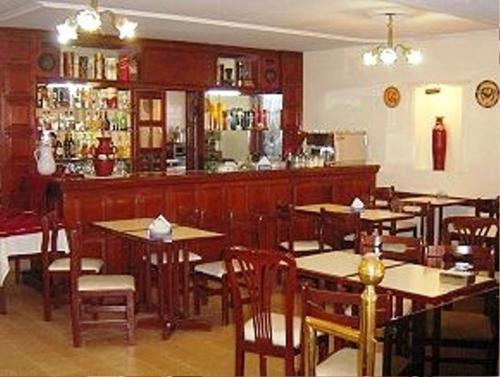 a restaurant with tables and chairs and a bar at Hotel Dora in Termas de Río Hondo