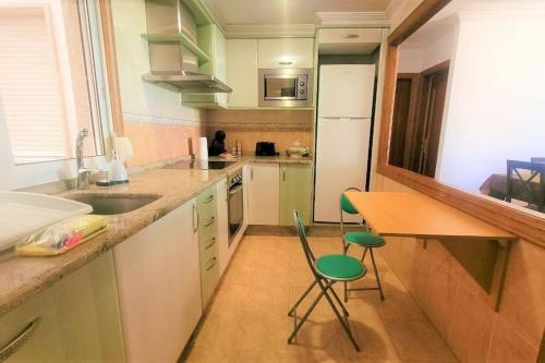 a kitchen with a sink and a table and chairs at Céntrico apartamento en Redondela in Redondela