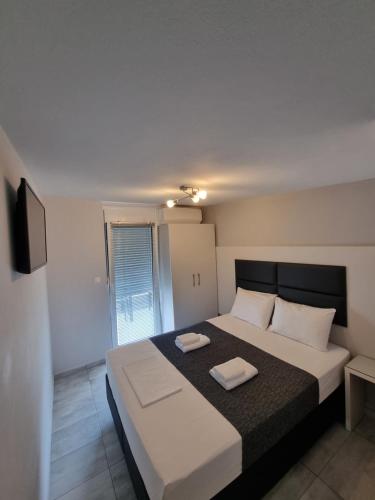 レプトカリヤにあるAlexion Apartmentsのベッドルーム1室(ベッド1台、タオル2枚付)