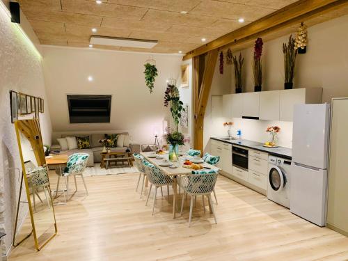 a kitchen and living room with a table and chairs at Alte Scheune, Parken-WLAN-Küche-Bad-Tierlieb in Däniken