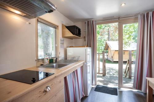 a kitchen with a sink and a refrigerator at CityKamp Lyon in Dardilly