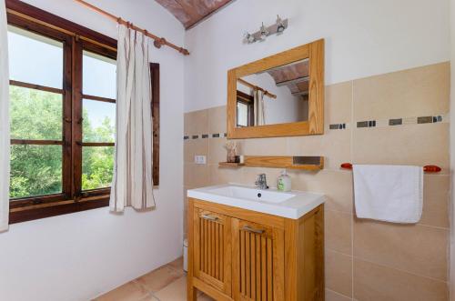 a bathroom with a sink and a mirror and a window at Finca Es Galliner in Felanitx