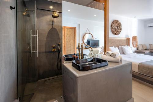 a bathroom with a sink and a shower and a bed at Smy Mediterranean White Santorini in Kamari