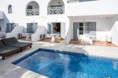 a swimming pool in the middle of a house at Smy Mediterranean White Santorini in Kamari