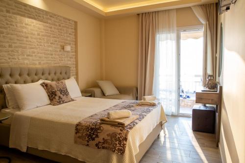 a bedroom with a bed and a large window at Luxury Plateia Rooms in Perea